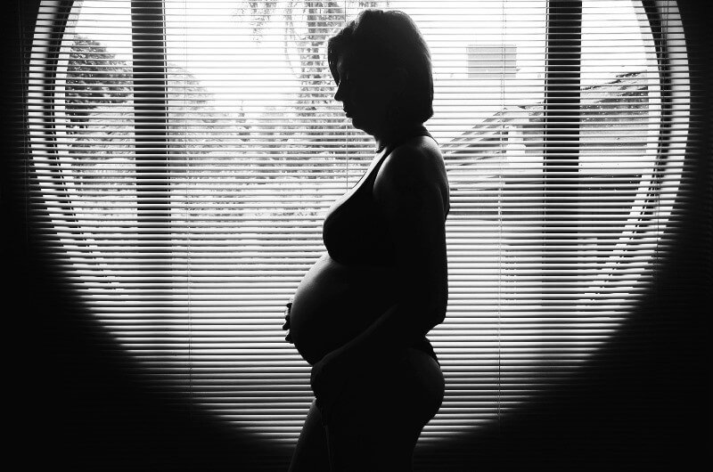 Gravidez Psicológica: Mulher grávida com mão na barriga