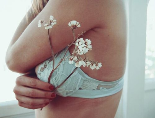 Sexo na Gravidez: Mulher de sutiã segurando uma flor